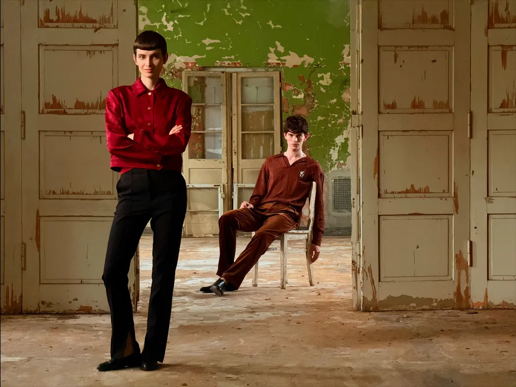 照片 app 展示 Pro 级拍摄系统在不同焦距下的拍摄视角，焦距切换到 100 毫米时，镜头拉远视角更广，继续将站在门厅内的一位女子收入画面中。